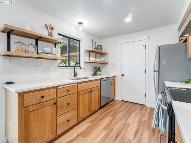 a kitchen with stainless steel appliances white cabinets and wooden floors