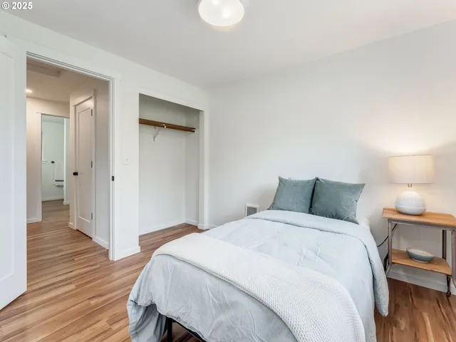a bedroom with a bed and wooden floor