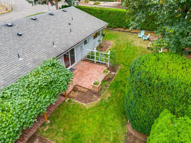 an aerial view of a house with pool garden and lots of trees