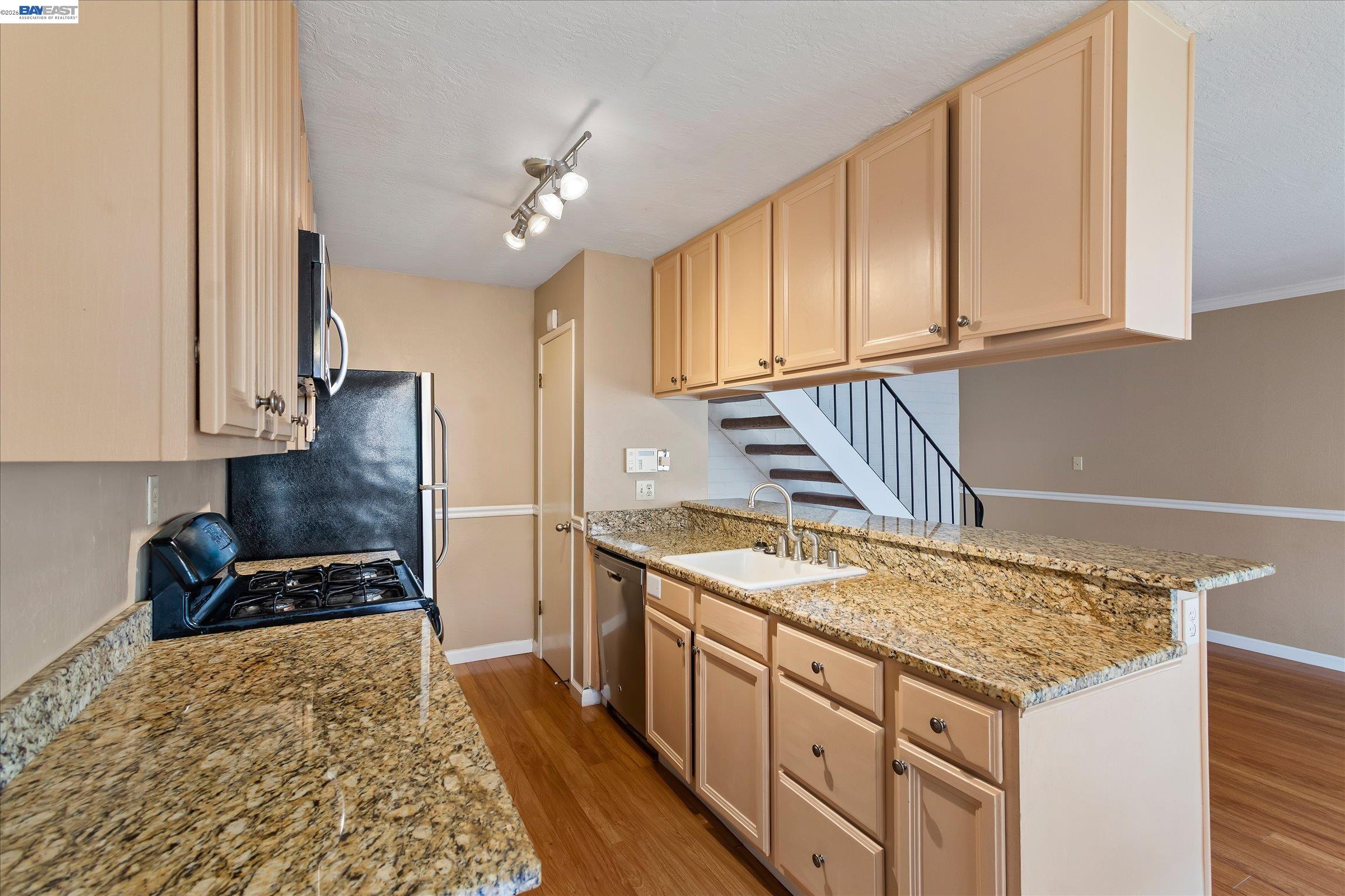 2243 Segundo Court, Unit 2 Pleasanton, CA 94588 - Photo 11 of 22 a kitchen with granite countertop a stove and cabinets