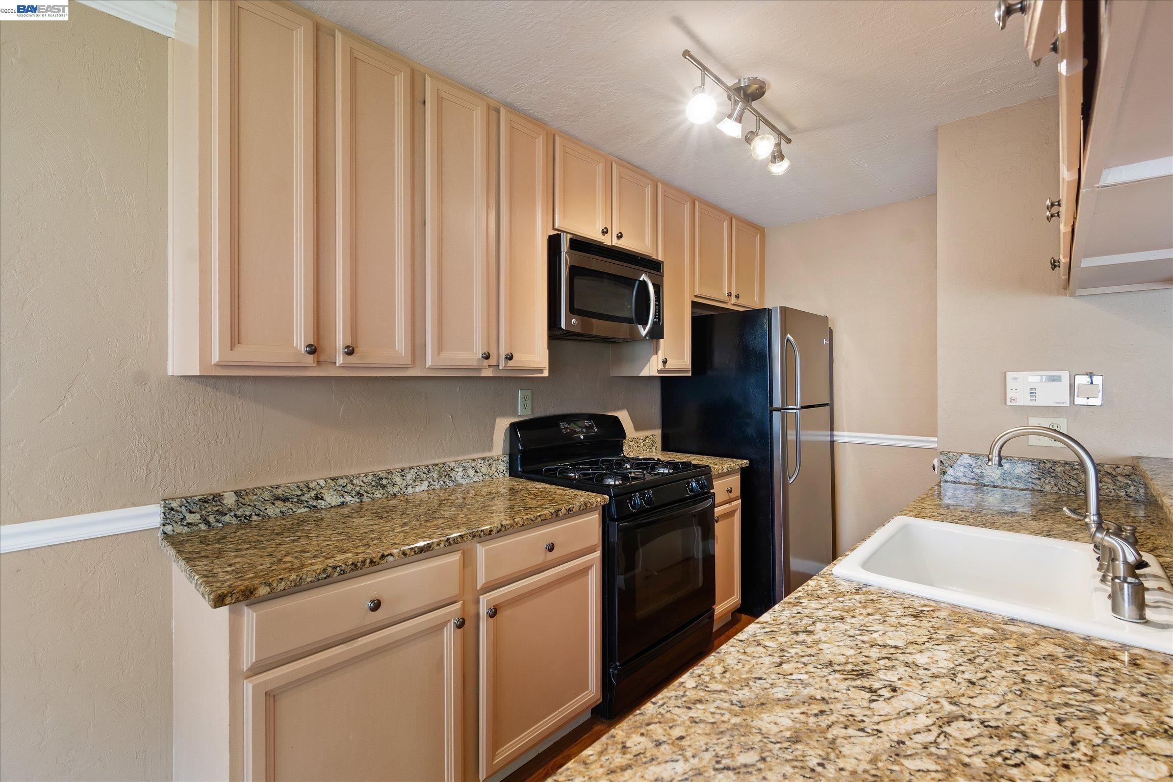 2243 Segundo Court, Unit 2 Pleasanton, CA 94588 - Photo 12 of 22 a kitchen with stainless steel appliances granite countertop a stove refrigerator sink and microwave