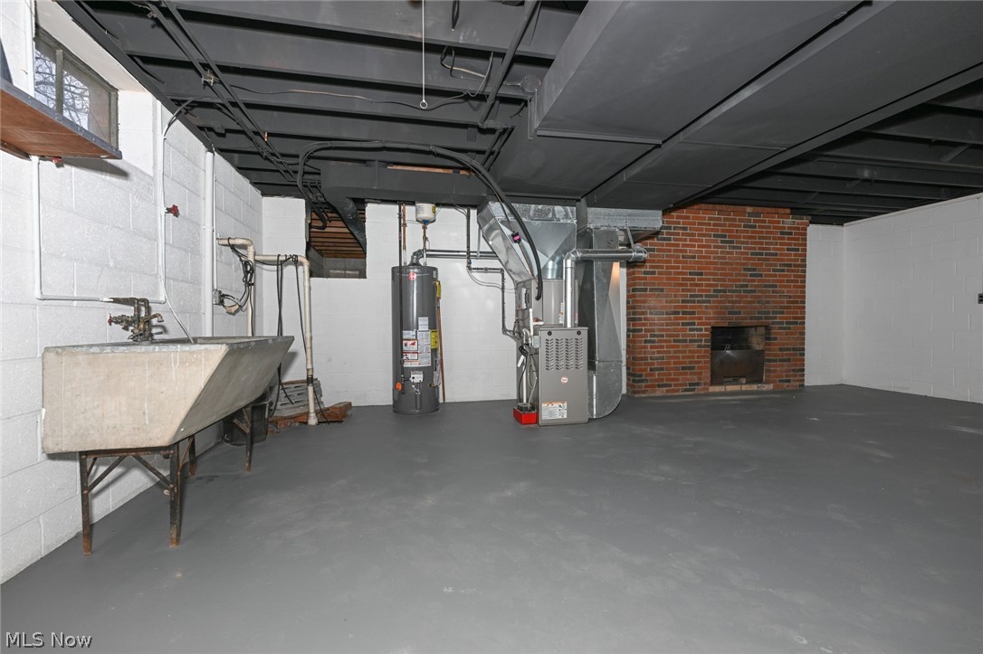 773 Bishop Road Cleveland, OH 44143 - Photo 24 of 34 Basement featuring water heater, heating utilities, a fireplace, and brick wall