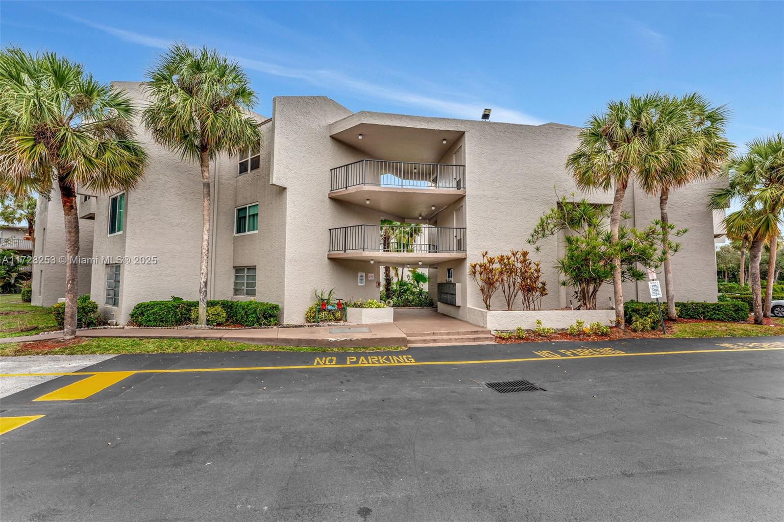 3100 Riverside Drive, Unit 306 Coral Springs, FL 33065 - Photo 2 of 2 a view of a house with a yard and palm trees