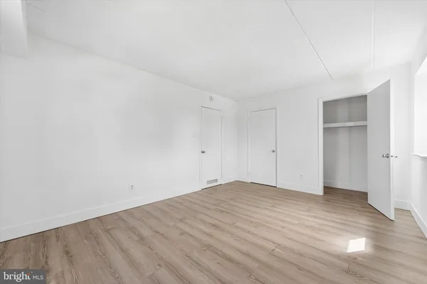 a view of empty room with wooden floor