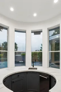 a kitchen with a sink and a large mirror