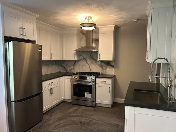 a kitchen with stainless steel appliances granite countertop a refrigerator sink and stove