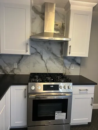 a stove top oven sitting inside of a kitchen