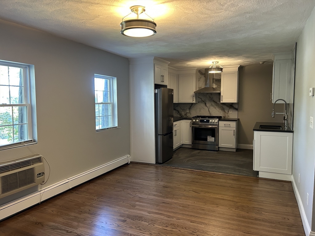 18 Ashcroft Street, Unit 301 Dedham, MA 02026 - Photo 8 of 14 a kitchen with stainless steel appliances granite countertop a stove and a refrigerator