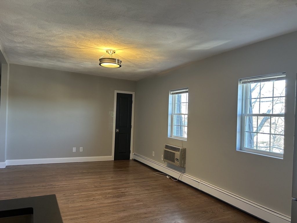 18 Ashcroft Street, Unit 301 Dedham, MA 02026 - Photo 9 of 14 a view of an empty room with wooden floor and a window