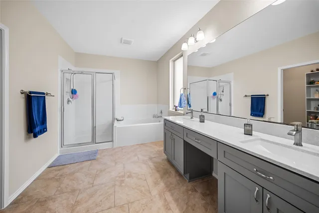 a spacious bathroom with a double vanity sink mirror and bathtub