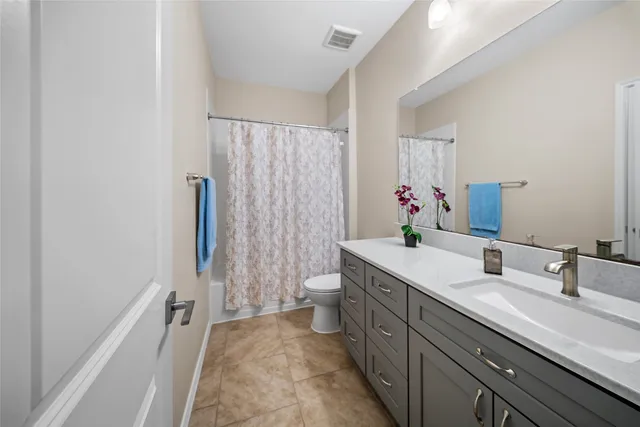 a bathroom with a double vanity sink toilet and shower