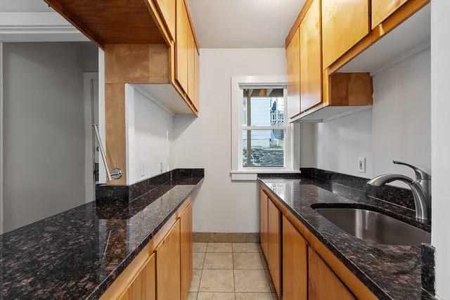 a kitchen with granite countertop a sink and a stove