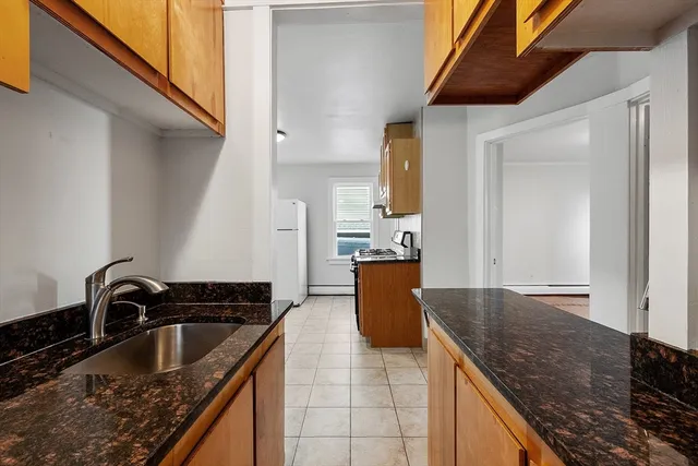 a view of a kitchen with refrigerator and wooden floor
