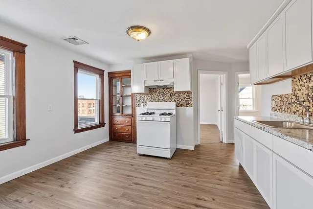 a kitchen with white cabinets and white appliances
