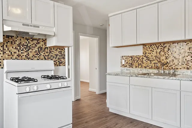 a kitchen with white cabinets and white appliances