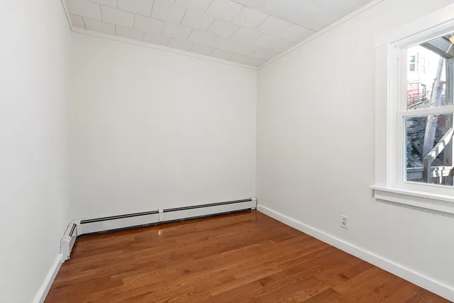 wooden floor in an empty room with a window