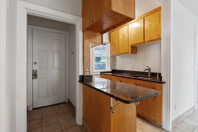 a kitchen with granite countertop a sink and a stove top oven