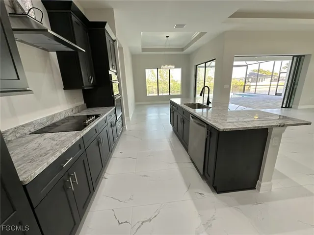 a kitchen with granite countertop sink stove and cabinets