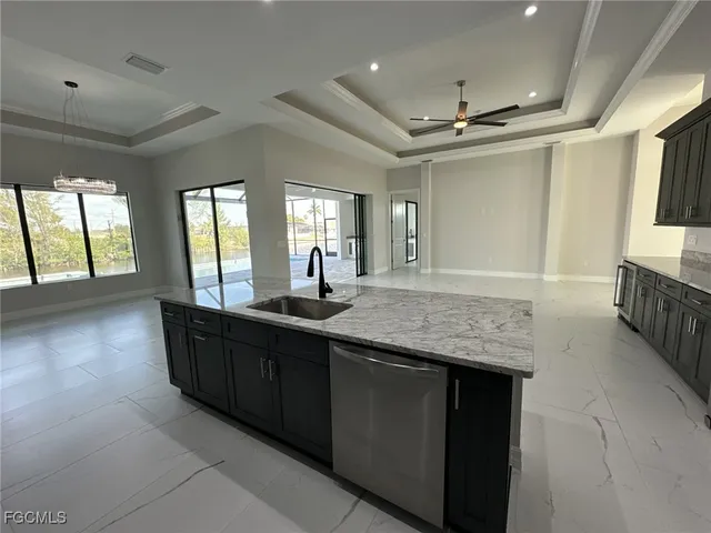 an open kitchen with granite countertop a sink and dishwasher with a large kitchen island