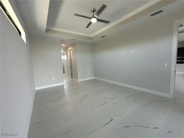 en empty room with windows and fan