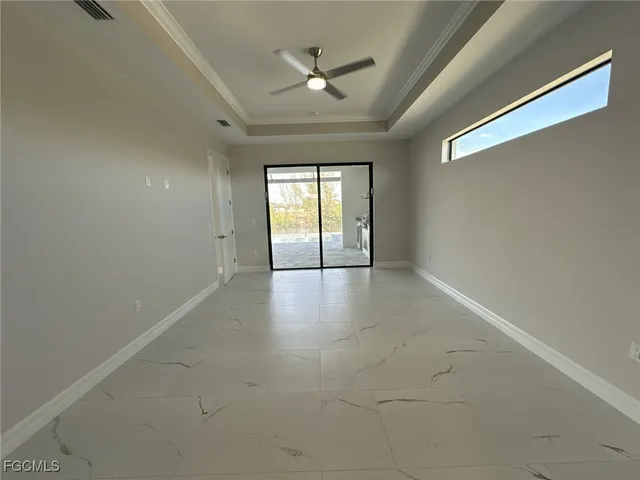 an empty room with windows and ceiling fan