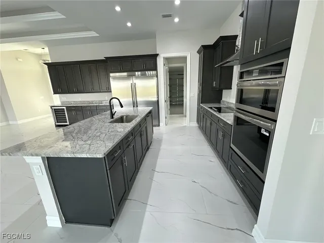 a kitchen with stainless steel appliances granite countertop a sink and a stove