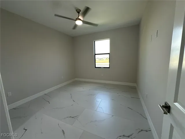 en empty room with windows and fan