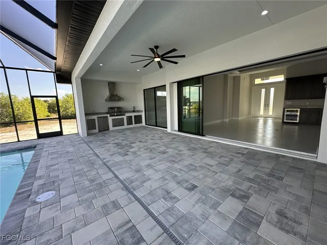 a view of a livingroom with furniture chandelier and windows