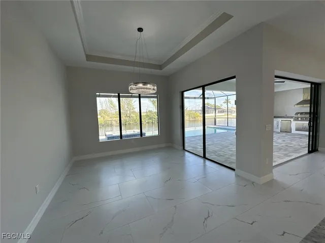 an empty room with windows and chandelier