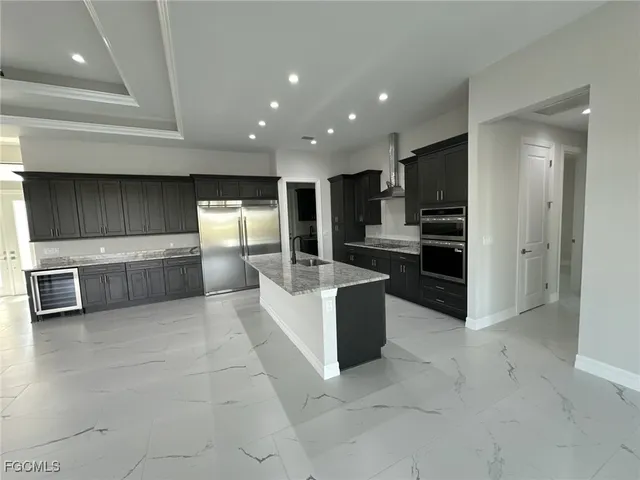 a large kitchen with stainless steel appliances granite countertop a large counter top and a stove top oven