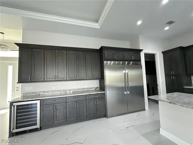 a kitchen with stainless steel appliances granite countertop a refrigerator and a sink