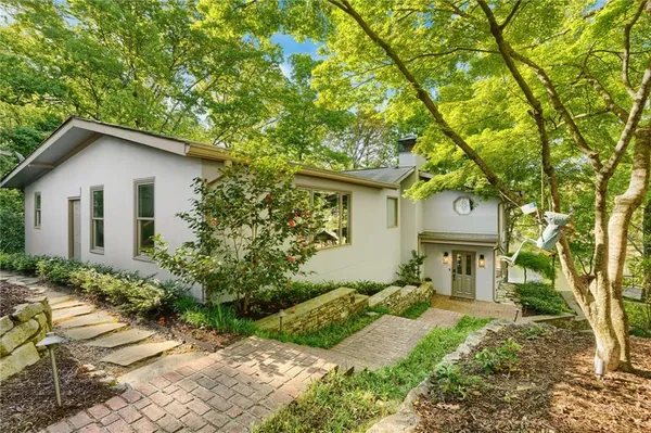 a front view of a house with a yard and tree