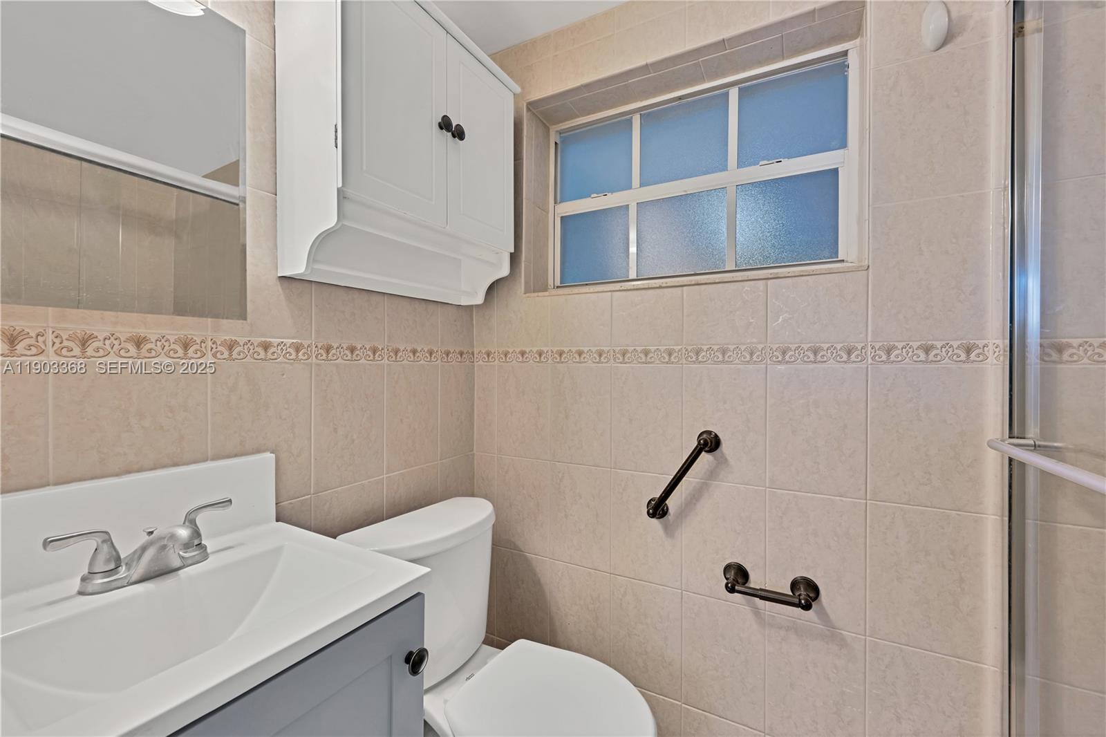 818 Northeast 3rd Street Hallandale Beach, FL 33009 - Photo 11 of 24 a bathroom with a sink a toilet and a mirror