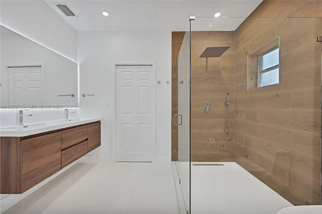 a spacious bathroom with a shower sink and mirror