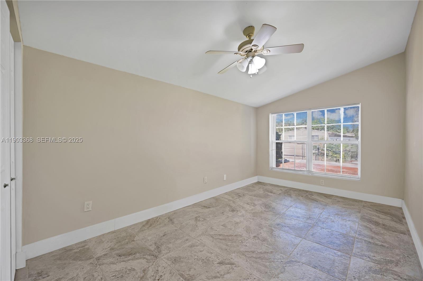 818 Northeast 3rd Street Hallandale Beach, FL 33009 - Photo 16 of 24 an empty room with chandelier fan and windows