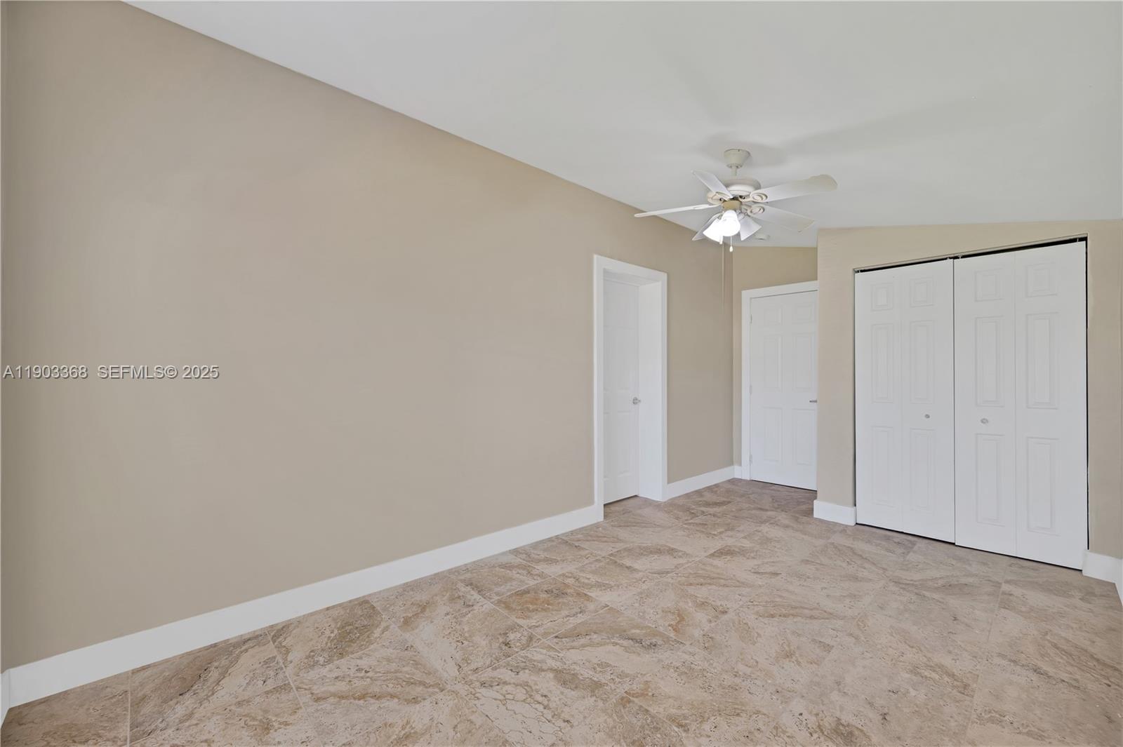 818 Northeast 3rd Street Hallandale Beach, FL 33009 - Photo 17 of 24 an empty room with a chandelier fan and closet