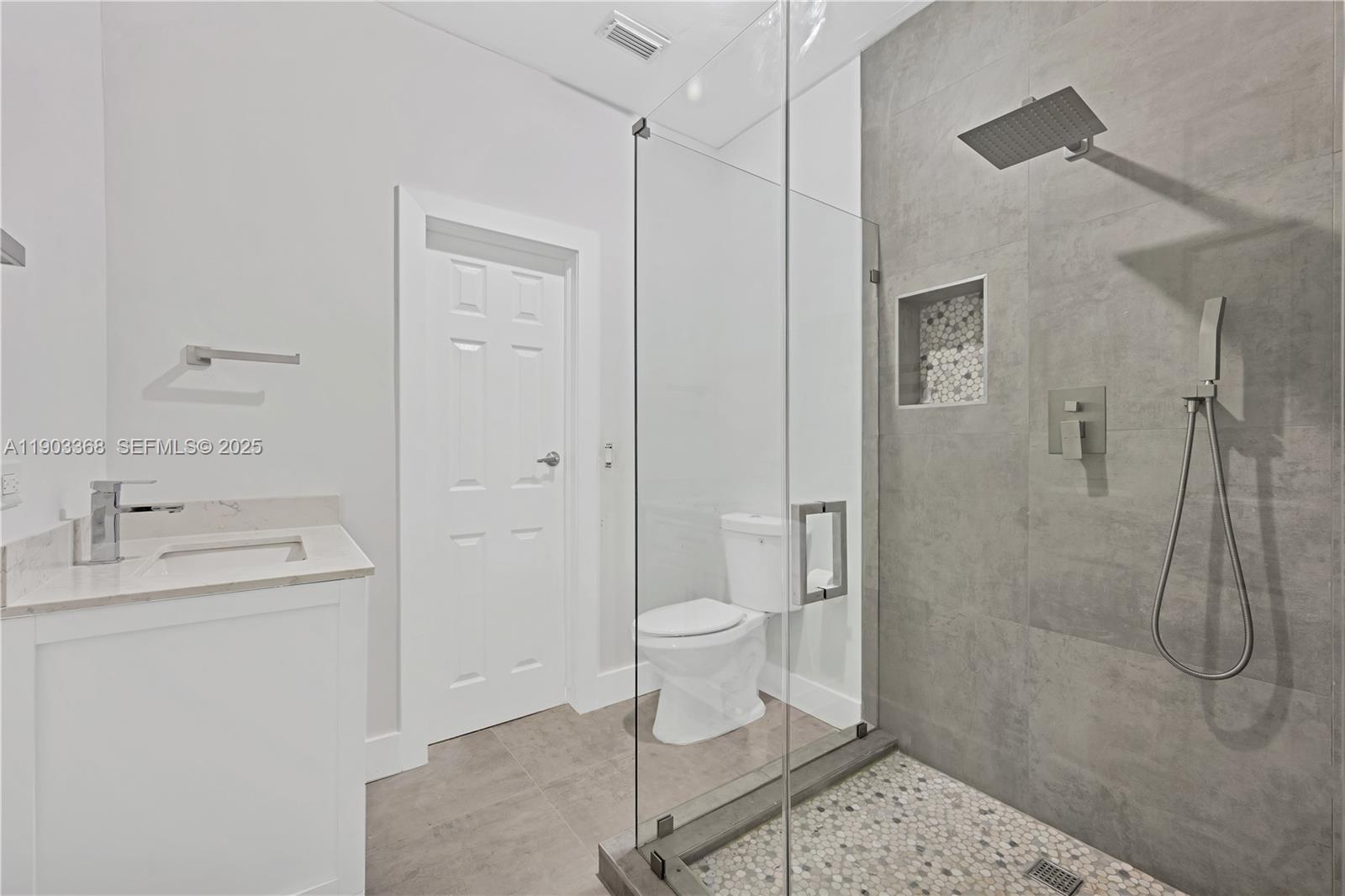 818 Northeast 3rd Street Hallandale Beach, FL 33009 - Photo 18 of 24 a bathroom with a granite countertop sink a toilet and shower