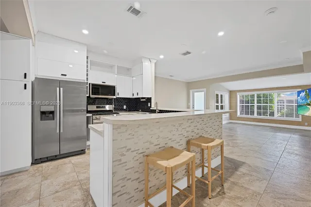 a kitchen with stainless steel appliances granite countertop a refrigerator and a stove top oven