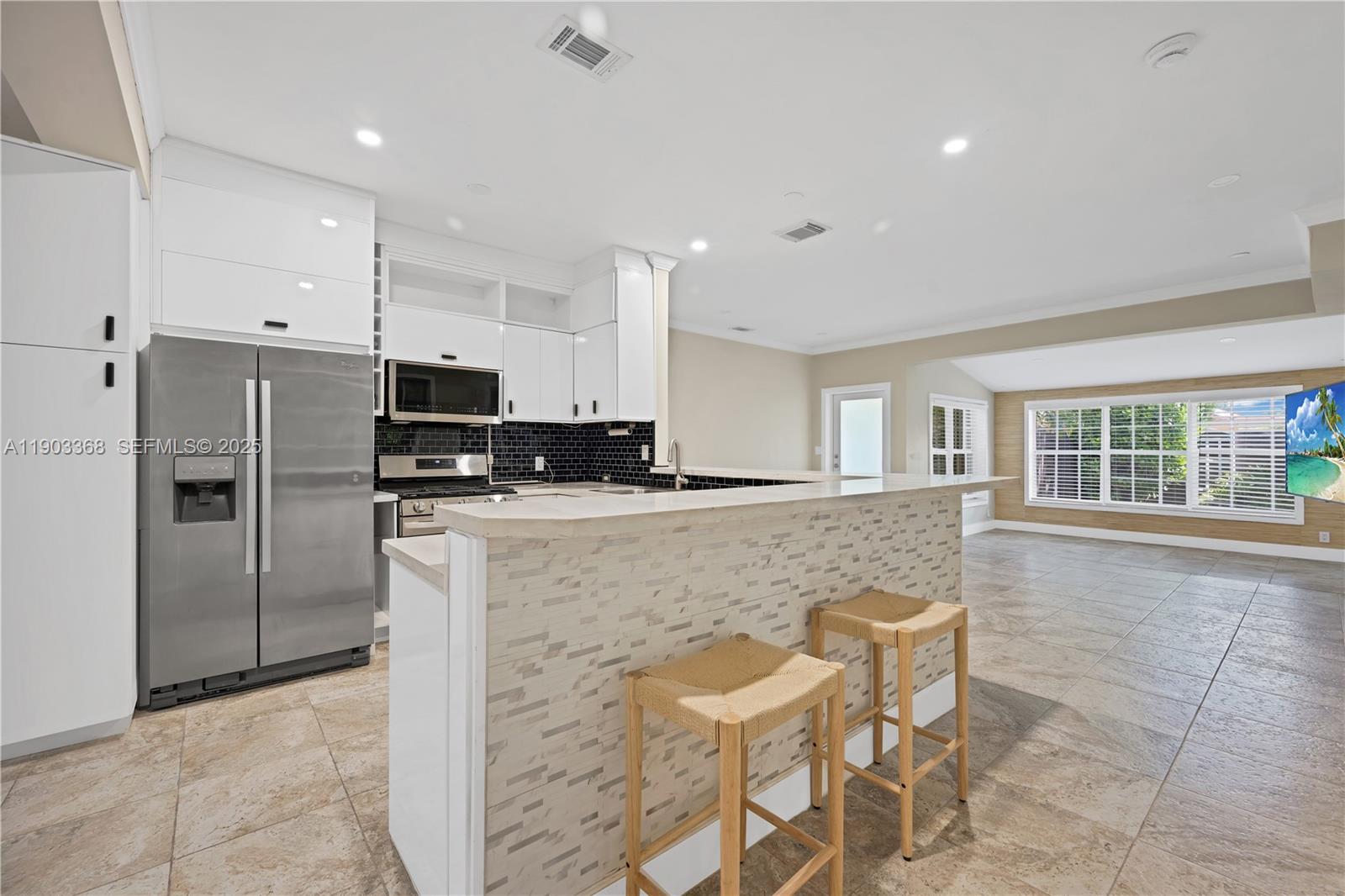 818 Northeast 3rd Street Hallandale Beach, FL 33009 - Photo 6 of 24 a kitchen with stainless steel appliances granite countertop a refrigerator and a stove top oven