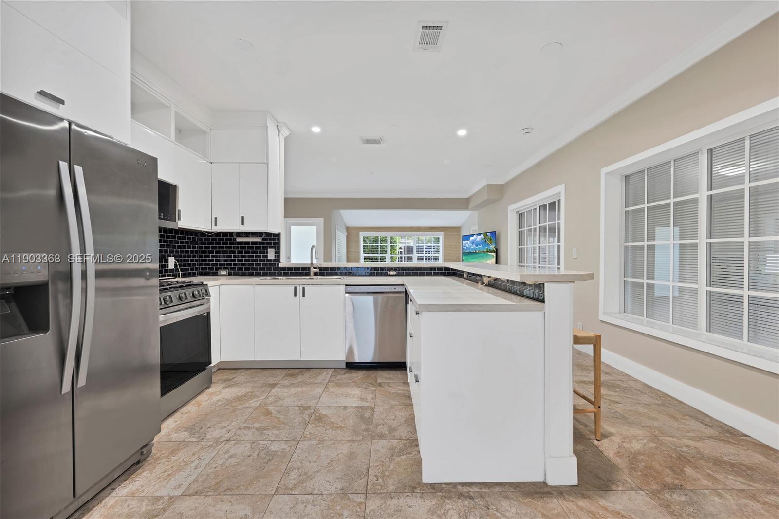 818 Northeast 3rd Street Hallandale Beach, FL 33009 - Photo 7 of 24 a kitchen with a refrigerator sink and cabinets