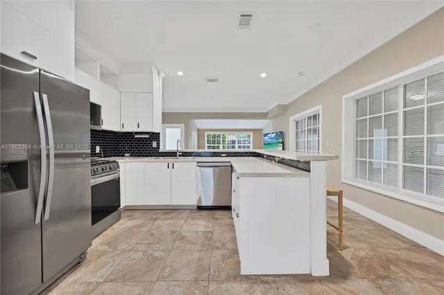 a kitchen with a refrigerator sink and cabinets