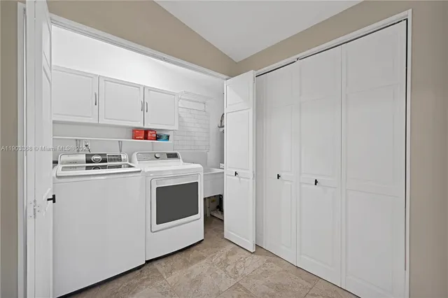 a utility room with cabinets washer and dryer