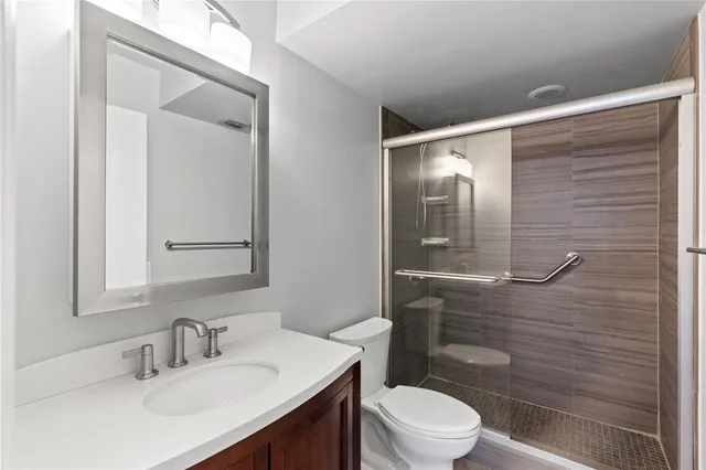 a bathroom with a sink a toilet and shower