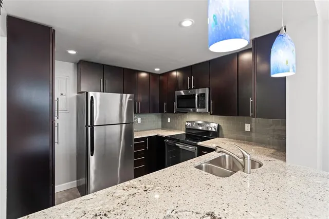 a kitchen with stainless steel appliances a refrigerator sink and microwave