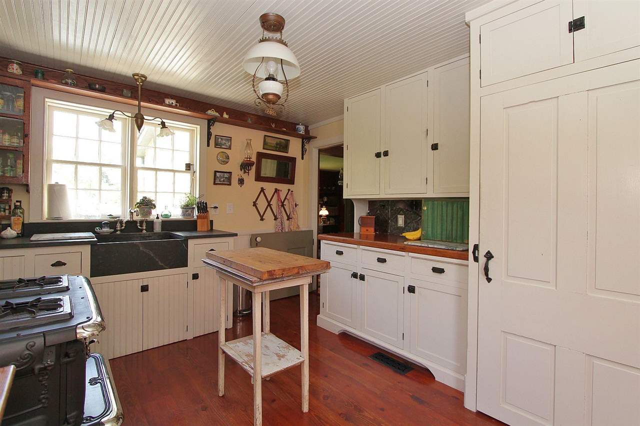 1108 Newport Road Raphine, VA 24472 - Photo 34 of 50 a kitchen with a stove a refrigerator a sink and white cabinets with wooden floor