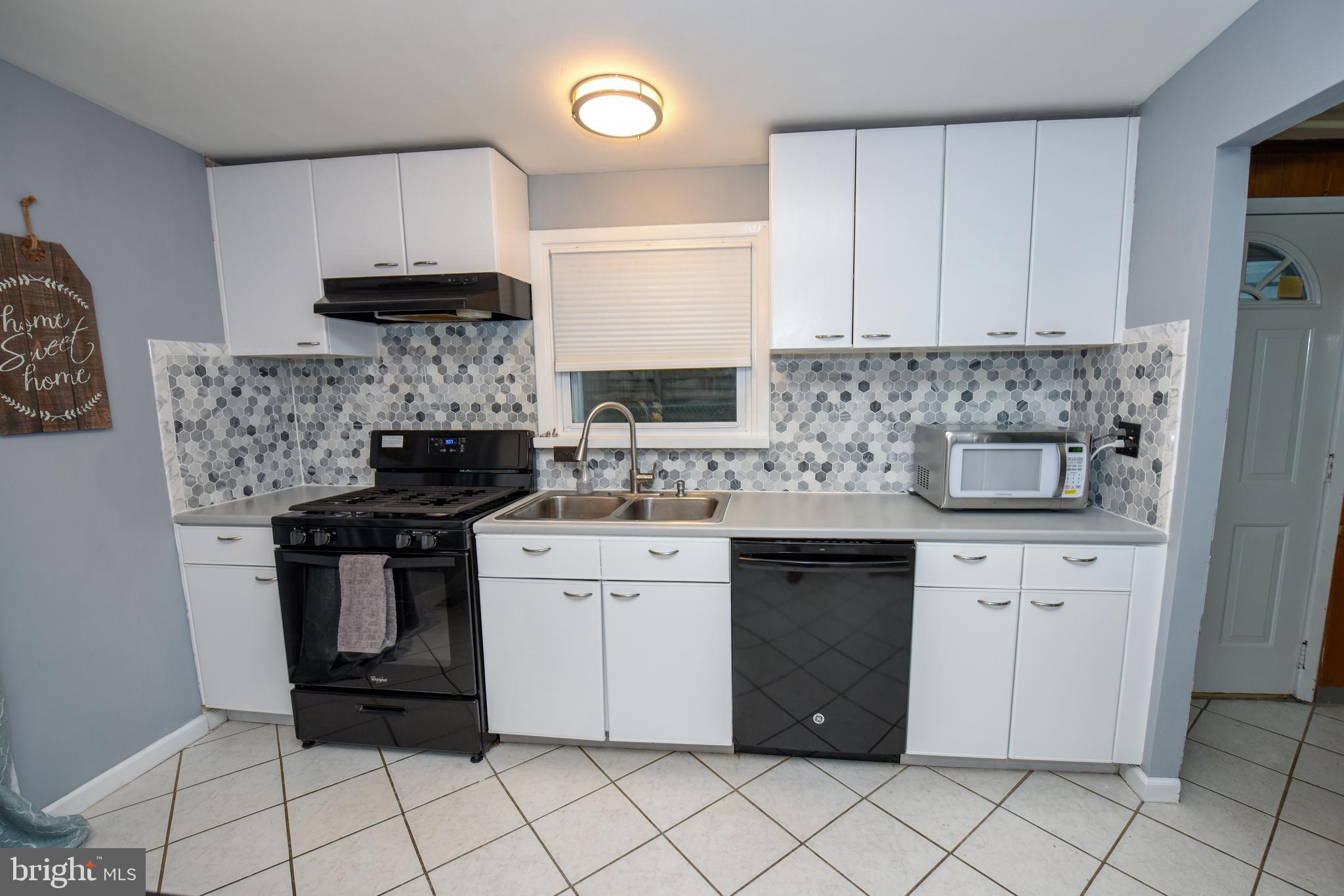 9332 Rising Sun Avenue Philadelphia, PA 19115 - Photo 8 of 27 a kitchen with a stove sink and cabinets