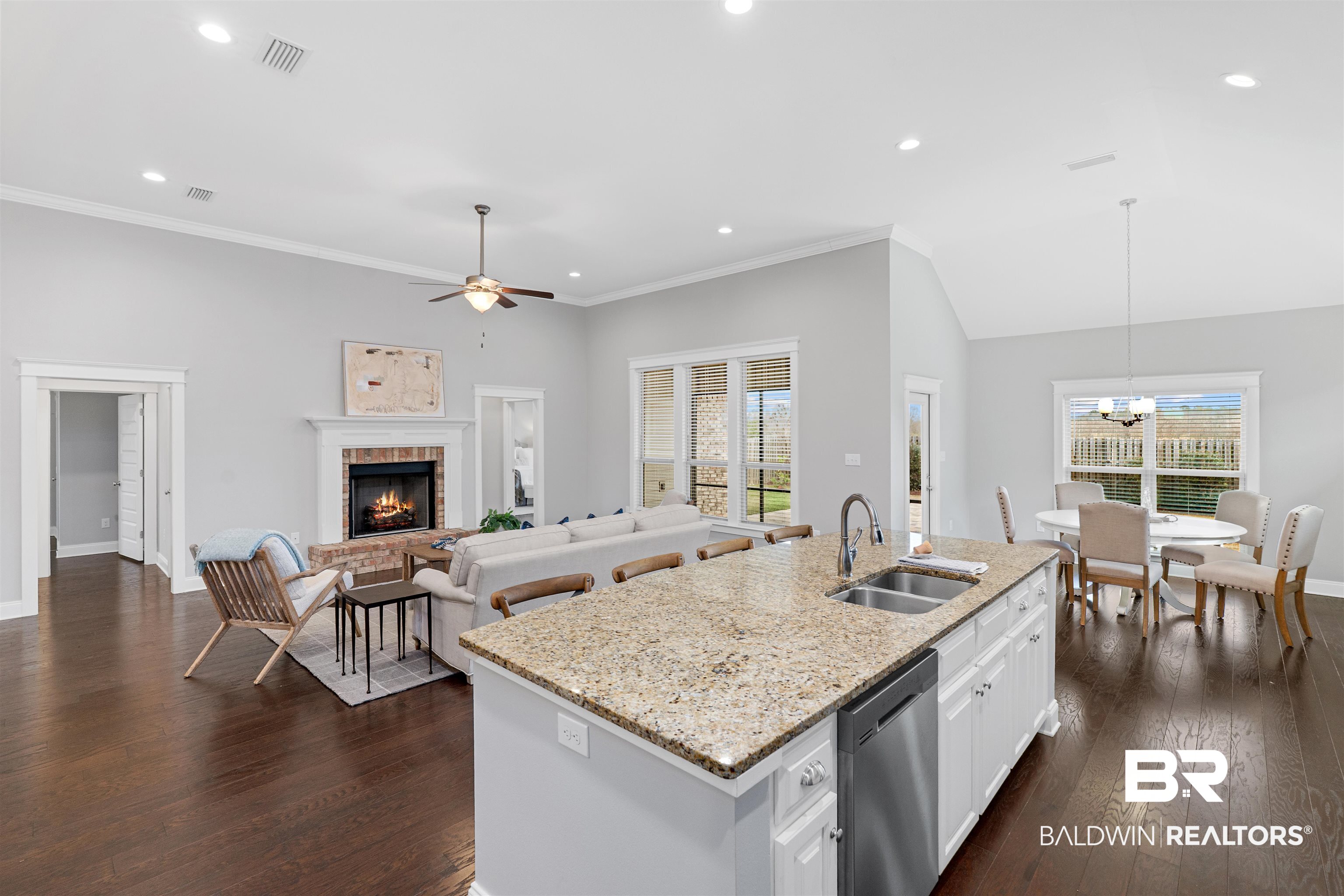 24838 Slater Mill Road Daphne, AL 36526 - Photo 14 of 46 Kitchen with light stone counters, white cabinets, ceiling fan, a brick fireplace, and dark wood-type flooring