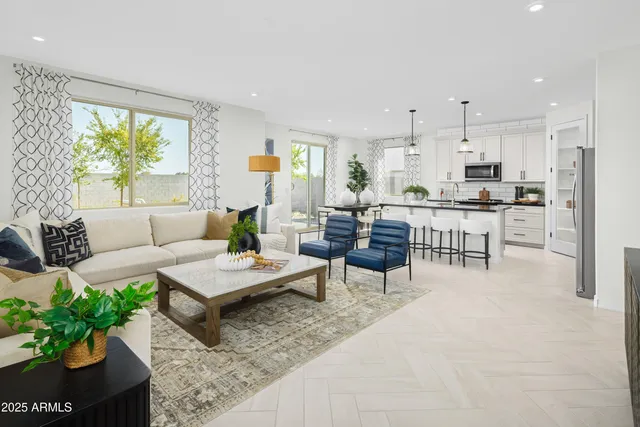 a living room with furniture kitchen and a large window