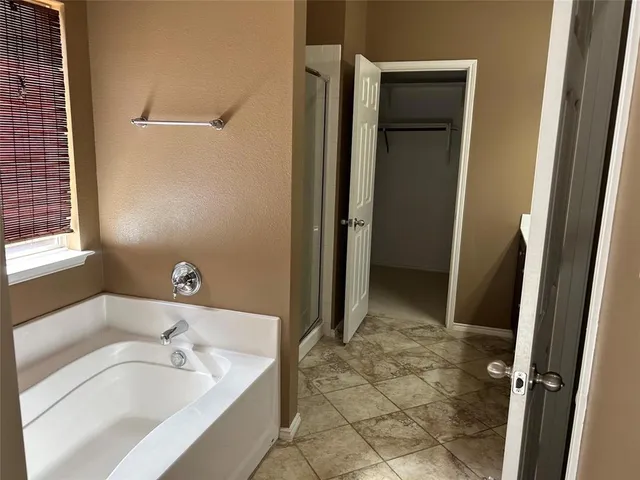 a spacious bathroom with a tub shower and a sink