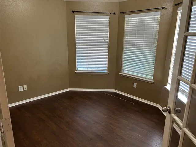 an empty room with wooden floor and a window